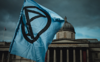 an Extinction Rebellion flag flies in front a museum