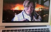image of a woman on a MacBook Air screen with an explosion behind her