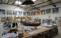 an artist's studio with paintings all around