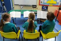 Photo of children having music lesson via internet