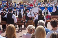 a pipe band performs in front of a crowd in glasgow