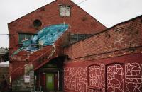 A photo of a red brick building with graffiti