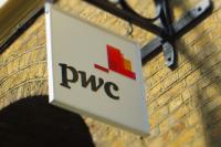 The PricewaterhouseCoopers logo hanging from the side of a building