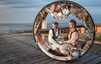 Photo of two people sat inside giant wheel
