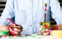 Photo of man with paintbrushes and pen