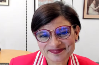 A screen shot of Shadow Culture Secretary Thangam Debbonaire in a Zoom call. She has short dark hair and wears a red jacket with matching glasses