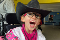 A Keep the Beat participant, she wears a cowboy hat, pink hoodie and glasses