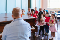 A music teacher playing piano for a class of children