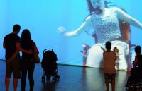 Photo of audience watching a film of a disabled dancer underwater