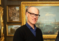 Will Gompertz photographed in a gallery of paintings.