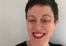 Anna Williams, Chief Operating Officer, Birmingham Royal Ballet. She is a white women with short brown hair. She is looking down and smiling. She wears red lipstick.