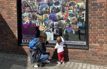 Mother and daughter looking at a window display at Hertford Theatre