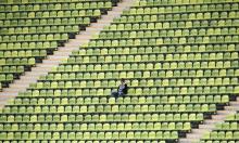 Photo of a man sitting in an empty stadium