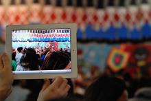 Photo of someone filming a children's concert on an iPad