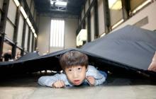 Photo of a boy under a big black sheet