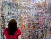 Photo of woman looking at wall of tiny images