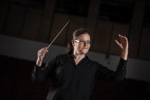 Anna-Maria Helsing, incoming Chief Conductor of BBC Concert Orchestra. She is depicted conducting at the 2018 Proms, against a black background.