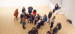 A group of people including a wheelchair user in an art gallery