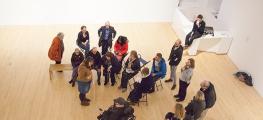 A photo of visitors in an art gallery, including a wheelchair user