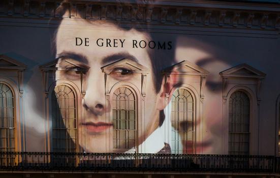 Photo of two faces projected onto a building