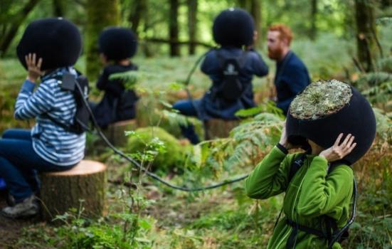 Photo of people wearing headsets in woodland