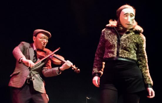Photo of performance of violinist and woman in masks