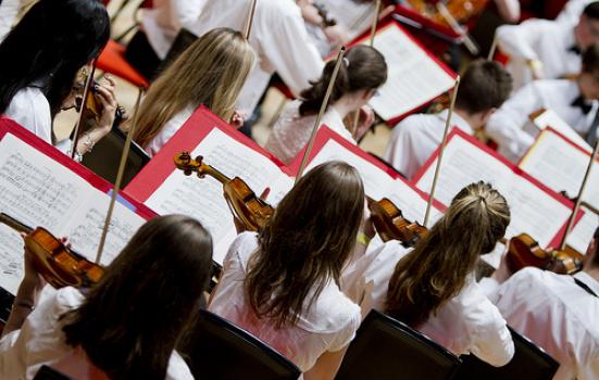 children playing violins in an orchestra