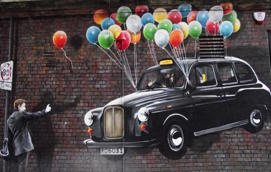 Photo of a mural of a man hailing a cab that is being lifted up by baloons