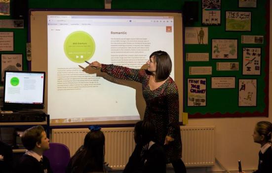 Photo of teacher pointing at screen