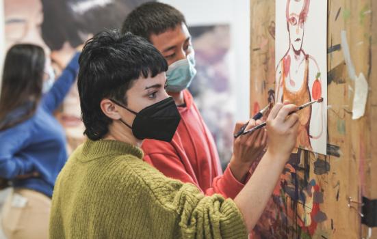 Artists in covid masks painting
