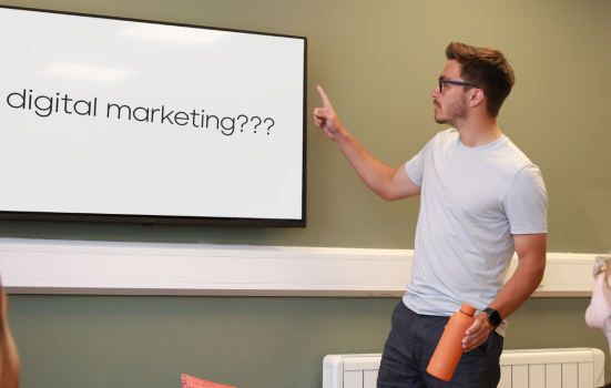 A person pointing at a whiteboard which reads 'digital marketing?'.