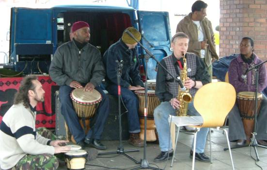 a group of men in a band playing instruments outside a van