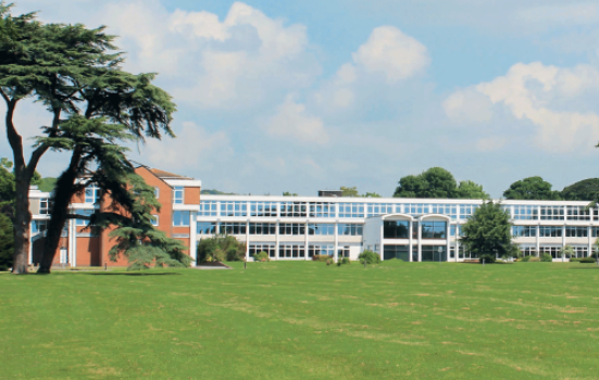 Worthing College building, captured from a distance across a field.