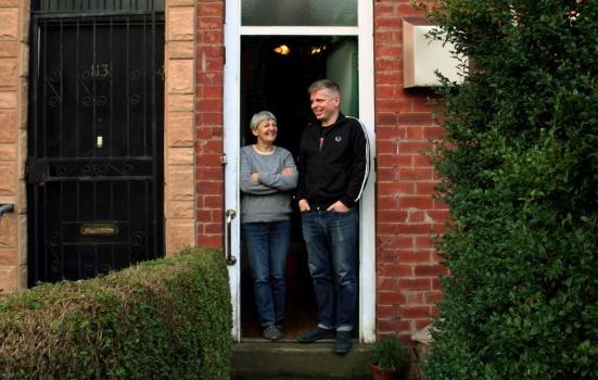 Karen Watson and Jon Wakeman, founder Directors of East Street Arts, Leeds. They stand in the doorway to a house, both smiling.