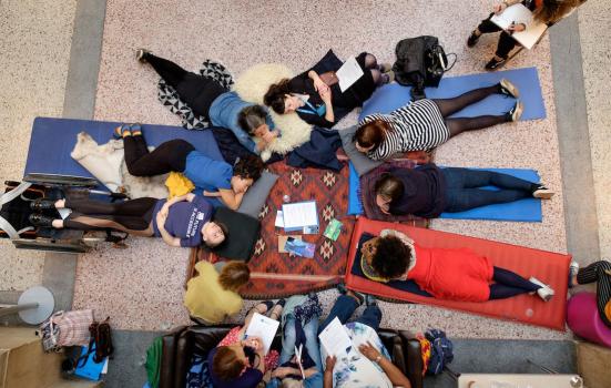 A group of diverse people gathered in a circle on the floor