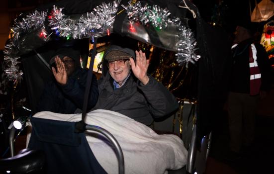 Photo of older person in carriage in parade