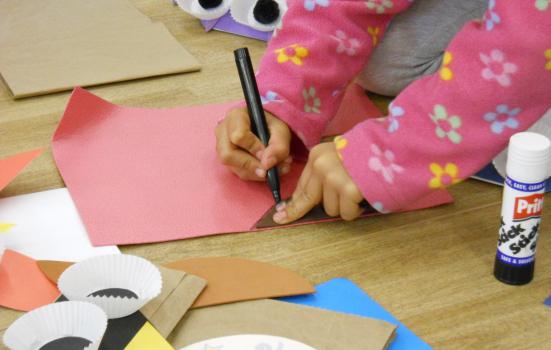 Child drawing on coloured papers