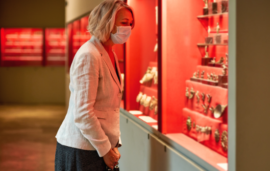 Woman wearing a face mask views an exhibition in a museum