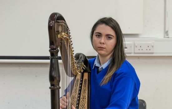 You girl in school uniform playing harp