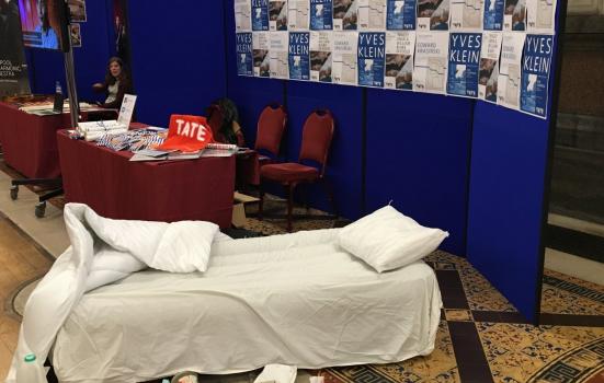 Photo of unmade bed on exhibition stand