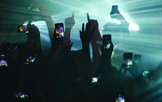 Photo of arms holding up phones