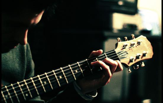 Photo of a man playing a guitar