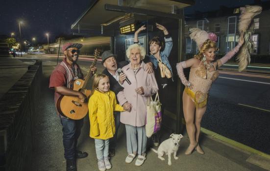 Photo of performers and family at a bus stop