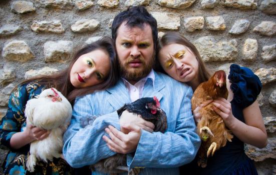 Photo of three people holding chickens