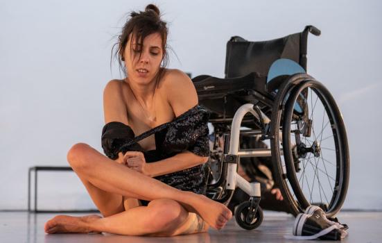 Diana performing on the floor in front of her wheelchair