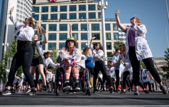 A group of young people dancing outside in front of a building as part of Birmingham 2022