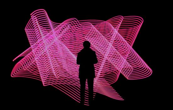 Silhouette of a person in front of a neon pink light display