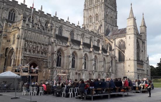 Audience watching ‘Coram Boy’ with Gloucester Cathedral in the background