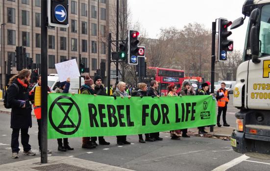 Protesters stopping traffic holding a 'Rebel for life' banner