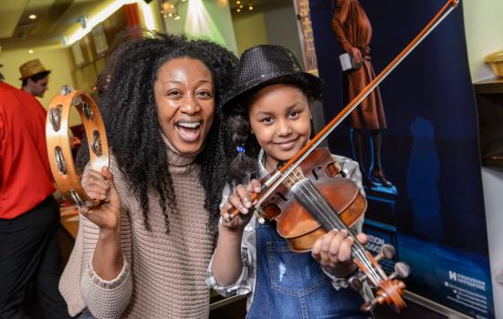 Photo of musician with young girl playing violin